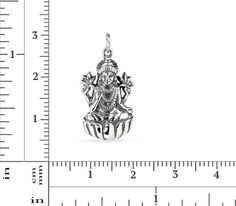 This 3.5mm high pendant is cast from .925 sterling silver oxidized to show detail. It represents Lakshmi, the goddess of wealth, fortune and prosperity in both Hindu and Buddhist religions. She is often depicted sitting like a yogi on a lotus pedestal, holding a lotus in her hand - the lotus being a symbol of good fortune, self-knowledge, and spiritual liberation. Her four arms represent the four directions, thus symbolizing the omnipresence and omnipotence of the Goddess, while her four hands r Symbolic Sterling Silver Jewelry For Puja, Symbolic Silver Jewelry For Puja, Sterling Silver Temple Jewelry For Meditation, Silver Symbolic Jewelry For Diwali, Spiritual Antique Silver Jewelry With Charms, Sterling Silver Engraved Jewelry For Puja, Antique Silver Spiritual Jewelry With Charms, Spiritual Antique Silver Charms Jewelry, Antique Silver Spiritual Charms Jewelry