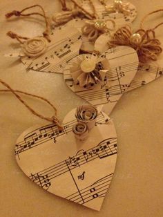 three heart shaped tags with musical notes and flowers on them, hanging from twine strings