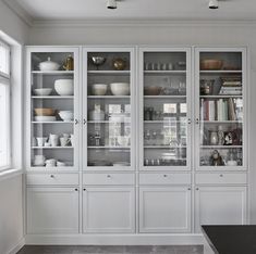 a kitchen with white cabinets and black counter tops in front of a large open window