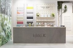 the kikik store is decorated in white and grey colors with an artistic wallpaper behind it