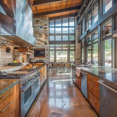 a large kitchen with wooden cabinets and stainless steel appliances, along with an open floor plan