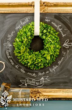 a chalkboard with a wreath hanging on it