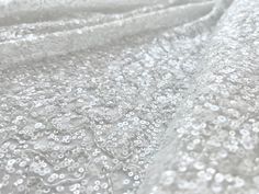 the fabric is white and has many small bubbles on it, as well as water droplets