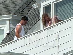 a man and woman standing on top of a roof