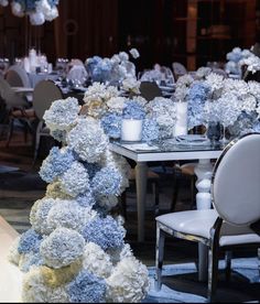 a dining room with tables and chairs covered in blue and white hydrangea flowers