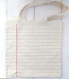 a white tote bag sitting on top of a wooden table