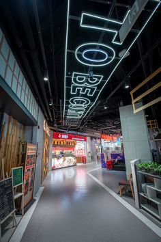 the inside of a restaurant with neon signs on the ceiling and food in the background