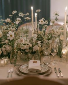 the table is set with white flowers and candles for an elegant dinner or reception party