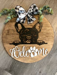 a wooden sign that says welcome with a dog's head and paw on it