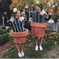 two people dressed in plant pots holding flowers