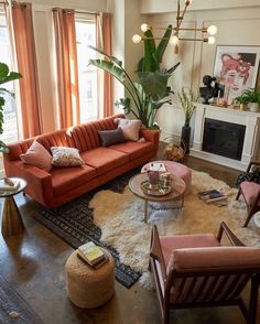 a living room filled with lots of furniture and plants on top of the floor next to a fire place