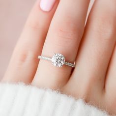 a woman's hand with a diamond ring on it