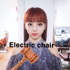 a woman holding a wooden judge's hammer in front of her face with the words electric chair on it