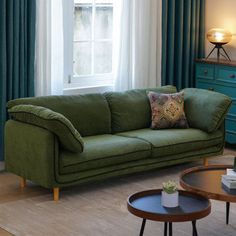 a living room filled with furniture and green curtains