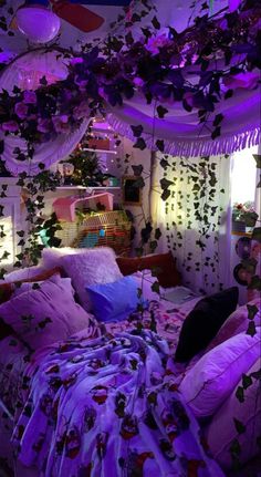 a bed covered in lots of pillows under purple lights