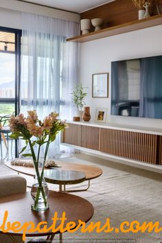 a living room filled with furniture and a flat screen tv mounted on the wall above it