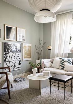 a living room filled with lots of furniture and pictures on the wall next to a window