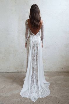 the back of a woman's wedding dress, with long sleeves and open shoulders