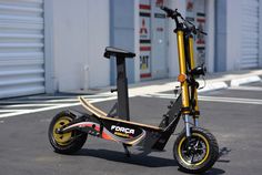 an electric scooter parked in front of a storage building with its wheels down