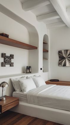 a bedroom with white walls and wood floors