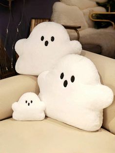 two stuffed ghost pillows sitting on top of a couch