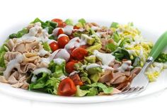 a white plate topped with salad and dressing