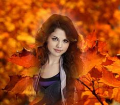 a beautiful young woman standing in front of autumn leaves