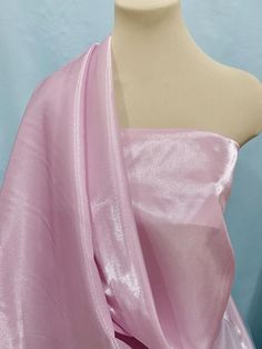 a mannequin is wearing a pink dress with a large shawl on it