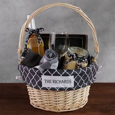 a wicker basket filled with wine, cheese and other items sitting on a table