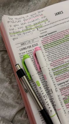 three pens sitting on top of an open bible