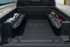 the back end of a pickup truck with its bed open and two coolers in it