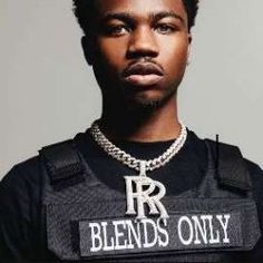 a young man wearing a black shirt and chain