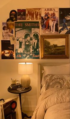 a bedroom with pictures on the wall and a bed in front of a night stand