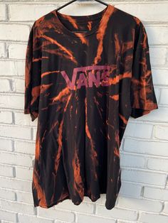 Step up your streetwear game with this unique and stylish Vans Reverse Tie Dye Shirt. Made from a high-quality upcycled tee, this shirt features a striking black and red reverse tie dye design that's perfect for skateboarders and streetwear enthusiasts. This shirt is perfect for anyone who wants to show off their individual style and love for streetwear fashion. The Vans logo on the front adds an extra touch of cool to this already stylish shirt. It's unisex design makes it a versatile piece that can be worn by anyone, and the upcycled tee material ensures that it's environmentally friendly and sustainable. sak The reverse tie dye design of this Vans shirt is eye-catching and unique, making it the perfect statement piece for any outfit. The shirt is comfortable and lightweight, making it p Tie Dye Crew Neck Top For Streetwear, Sporty Tie-dye Cotton T-shirt, Tie-dye Cotton Tops For Streetwear, Tie Dye Cotton Tops For Streetwear, Casual Tie Dye Tops For Streetwear, Grunge Style Cotton T-shirt With All Over Print, Sporty Tie Dye T-shirt With Crew Neck, Sporty Tie-dye T-shirt With Crew Neck, Tie Dye Letter Print Tops For Streetwear