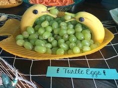 there is a plate with grapes and bananas in the shape of birds