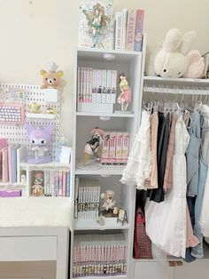 a white closet filled with lots of children's clothing and toys on top of shelves