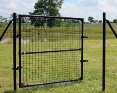 a black gate in the middle of a grassy field