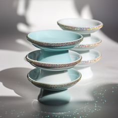 three plates stacked on top of each other in front of a white background with glitter