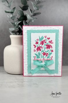 a card with flowers on it next to a potted plant