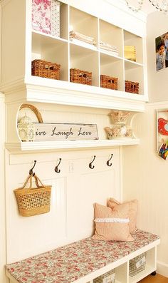 a white shelf filled with baskets and other items