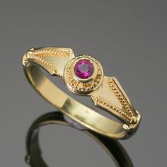 This 18K granulated gold ring adds a classic touch to any ensemble. A simple and elegant design combined with a timeless look make this Ruby Classical Ring the perfect accessory for a variety of occasions. 18K gold granulated ring with beautiful 0.22ct ruby. Currently a size 8, but each ring comes with free sizing and FREE SHIPPING! Unsure what ring size you are? It's always best to be sized by a professional jeweler, but if that is not available, you can use our special Ring Sizing Chart. Gold Ruby Ring With Center Stone In Round Band, Gold Ruby Ring With Center Stone And Round Band, 22k Yellow Gold Ruby Ring For Anniversary, Formal Yellow Gold Ruby Ring With Round Band, 22k Yellow Gold Ruby Ring, Elegant 22k Gold Rings With Bezel Setting, Elegant 22k Gold Ruby Ring, Classic Yellow Gold Ruby Ring With Birthstone, Gold Ruby Rings With Round Band