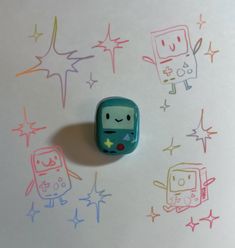 a small toy sitting on top of a table next to some colored stars and shapes