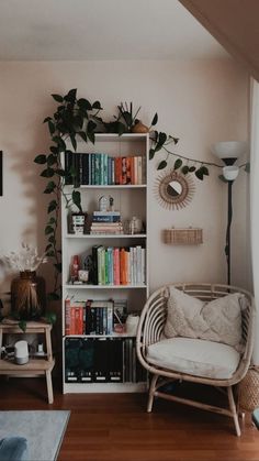 a living room filled with furniture and bookshelves covered in lots of green plants