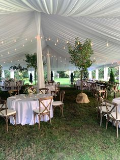 tables and chairs set up under a white tent