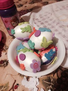 several decorated eggs in a bowl on a table