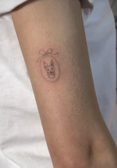 a small tattoo on the arm of a person with a dog in a circle around it