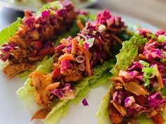 lettuce wraps with shredded meat and coleslaw on them are ready to be eaten