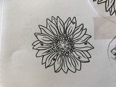 some black and white drawings on paper with flowers in the middle one has a sunflower