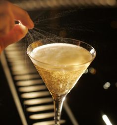 someone sprinkles sugar on the top of a martini glass in front of a piano