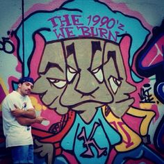 a man standing in front of a graffiti wall